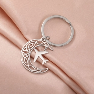 Silver stainless steel crescent moon keychain with Celtic patterns and airplane charm