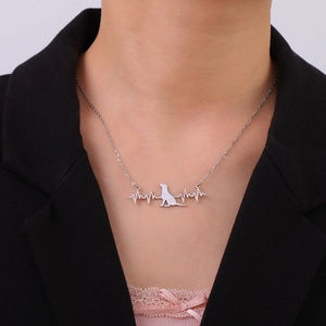 Minimalist stainless steel necklace featuring a heartbeat line and dog pendant on a model
