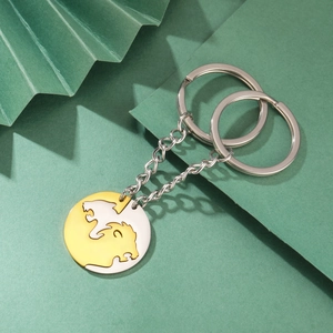 Matching lion pendants in gold and silver finish with stainless steel keychains on green paper