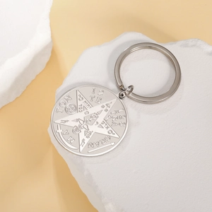 Macro detail of pentagram stainless steel keychain with engraved esoteric symbols