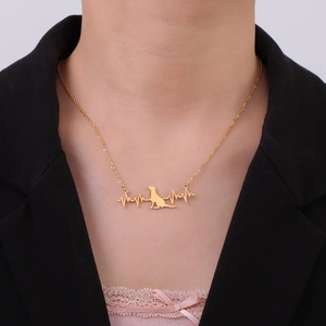 Golden stainless steel necklace featuring a unique heartbeat dog silhouette pendant on a model