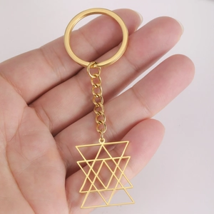 Close-up of golden hollow star pendant on hand showing scale and geometric details