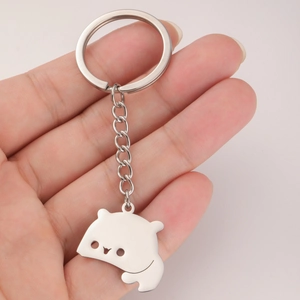 Polished silver stainless steel teddy bear charm keychain held in hand for scale