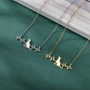 Detailed view of cat silhouette and ECG heartbeat line pendant in gold and silver finish