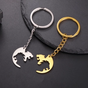 Detailed view of hollow dragon-shaped keychains in polished gold and silver steel