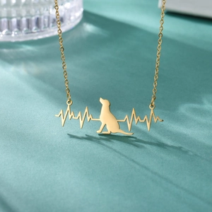 Close-up of golden stainless steel necklace with dog silhouette and heartbeat pendant