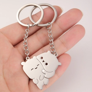 Close-up of interlocking polished stainless steel bear pendants on a keychain set