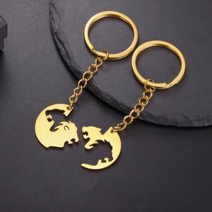 Detail of laser-cut lion and dragon silhouette pendants on golden stainless steel keychains