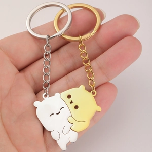 Detailed close-up of hugging bear puzzle keychains in polished gold and silver finishes