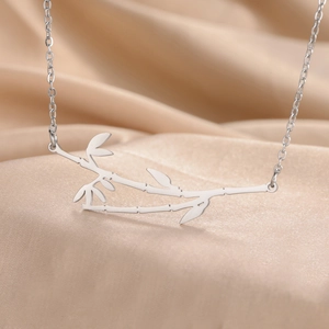 Detailed macro view of a bamboo-shaped pendant on a satin background for jewelry