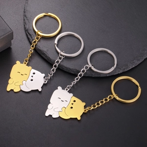 Macro detail of gold and silver cartoon bear charms on stainless steel keychains
