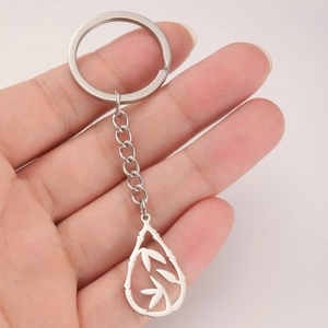 Bamboo leaf engraved teardrop pendant stainless steel keychain held in hand