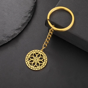 Minimalist gold stainless steel keychain with hollow mandala flower pendant on black stone