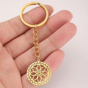 Detail of a gold stainless steel keychain featuring a hollow mandala flower pendant charm