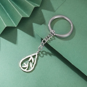 Polished stainless steel keychain with bamboo leaf pendant on a green background