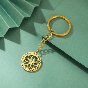 Macro detail of golden stainless steel keychain with hollow geometric flower pendant