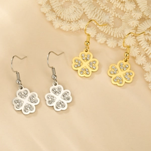 Détail de boucles d'oreilles trèfle en or et argent avec des strass brillants incrustés
