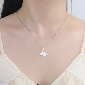Gros plan d'un pendentif carte du Texas avec détail d'étoile sur une chaîne argentée