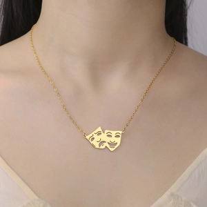 Λεπτομέρεια μενταγιόν θεατρικής μάσκας 18K χρυσό σε μια λεπτή αλυσίδα λαιμού