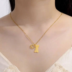 Gedetailleerde close-up van een goudkleurige poot- en botketting op de hals van een model