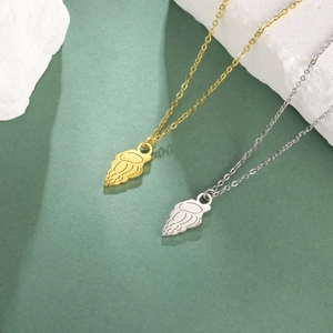 Sleek gold and silver jellyfish shell pendants on thin O-chains over stone background