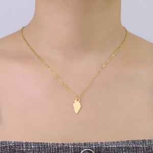 Close-up of golden conch pendant necklace on female collarbone with polished finish