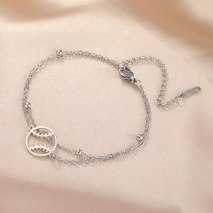 Detail eines silbernen Edelstahl-Doppelschichtarmbands mit Baseball-Anhänger und Karabiner