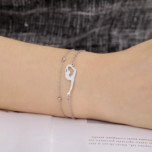 Macro shot of silver stainless steel bracelet featuring artistic gymnast silhouette charms