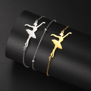 Detailed close-up of gold and silver stainless steel bracelets with ballet dancer charms