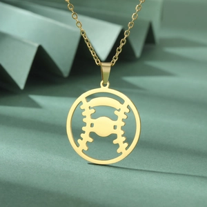 Vue macro détaillée du collier avec pendentif baseball doré sur fond vert texturé
