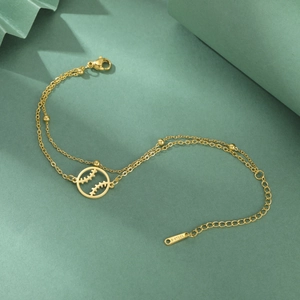 Detailopname van de gouden dubbellaagse roestvrijstalen armband met honkbalbedel