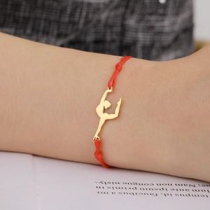Detailed close-up of a red braided cord bracelet with a golden gymnast silhouette charm