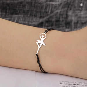 Detailed shot of a silver ballet dancer pendant with black woven cord on woman's wrist