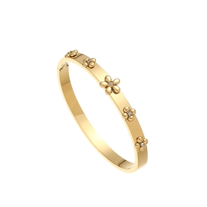 Détail macro du bracelet en acier inoxydable doré avec cinq motifs floraux diamantés