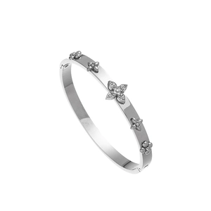 Détail macro d'un bracelet en acier argenté avec motifs trèfles et cristaux fins