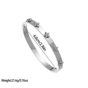 Détail d'un bracelet en acier inoxydable argenté avec fleurs serties et 6,0 cm de diamètre