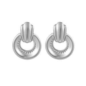 Détail de boucles d'oreilles en acier titane argenté avec textures verticales industrielles