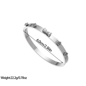 Detailed macro view of silver steel bangle with 3D rose and bow floral ornaments
