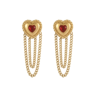 Detail of vintage gold heart earrings with red gemstones and hanging fringe chains