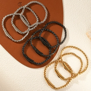 Détail de bracelets tressés en acier inoxydable en or, argent et noir avec fermoirs magnétiques