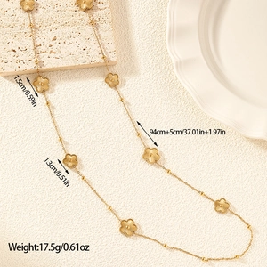 Macro detail of gold flower necklace with radial texture and 1.5cm floral charms