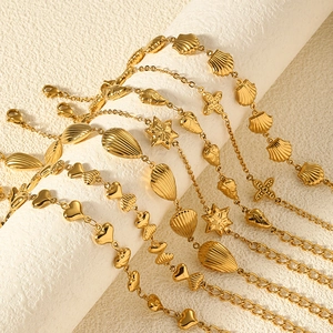 Close-up of gold plated stainless steel necklaces with heart and shell charms