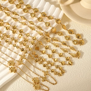 Detailed macro shot of 18k gold plated stainless steel pendants with heart and leaf charms