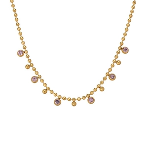 Detail of 18k gold plated titanium necklace featuring purple gems and golden beads
