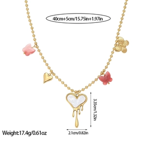 Collana a sfere dorate con farfalle rosa e ciondolo a cuore bianco su sfondo bianco puro