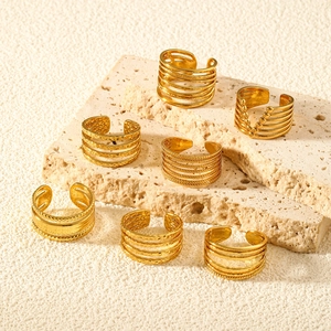 Adjustable gold star and moon stainless steel ring set on a natural travertine display