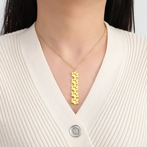 Primer plano del collar dorado de acero inoxidable con colgantes de huellas de gato en modelo