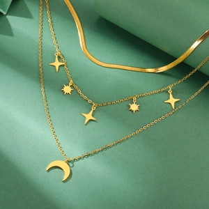 Detalle de collares dorados en capas con colgantes de estrella y luna creciente de estilo punk