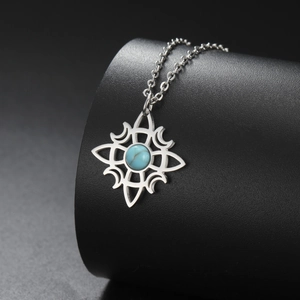 Macro detail of Celtic knot necklace with blue stone on a black texture pedestal