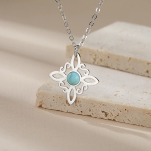 Detail of silver Celtic knot necklace featuring a round sky blue gemstone on stone decor